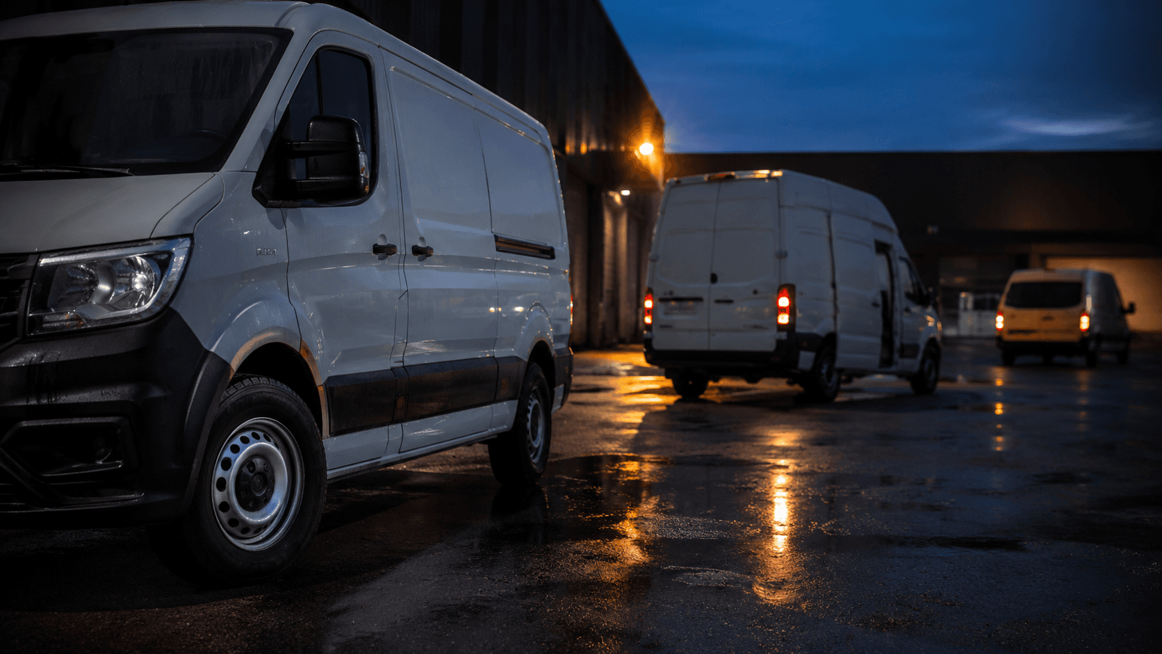 A line of commercial vans photographed low at their front wheels