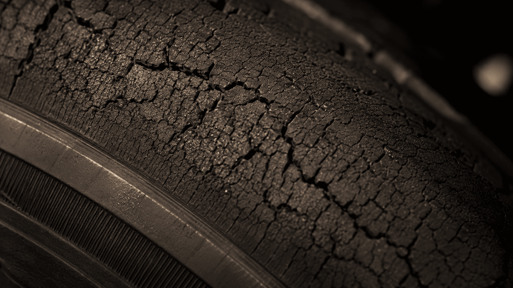 Extreme close-up of a tyre sidewall covered in fine age cracks